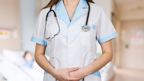 A clinician in scrubs with a stethoscope